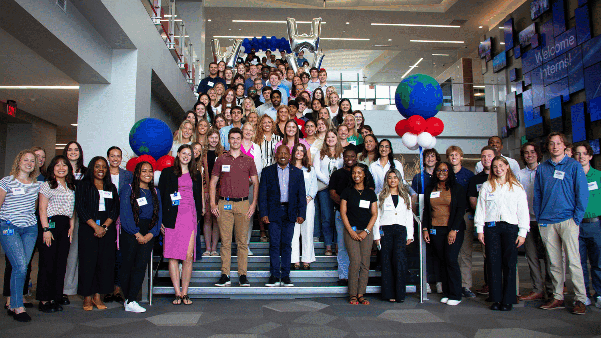 Group of WWT interns on stairs in lobby of global headquarters, celebrating the start of an internship program.