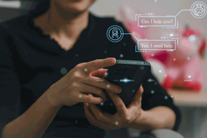 A person using a smartphone with AI chatbot interface graphics displayed.