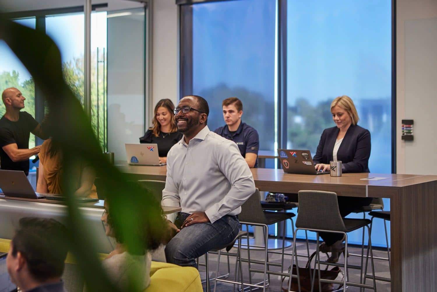 Multiple people engaged in a presentation, sitting in a conference room