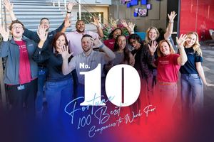 Employees celebrating World Wide Technology's rank with hands raised